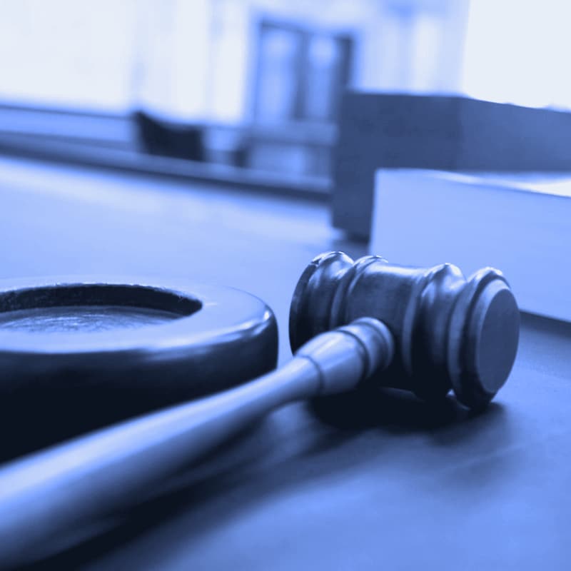 A judge's gavel on a courtroom bench